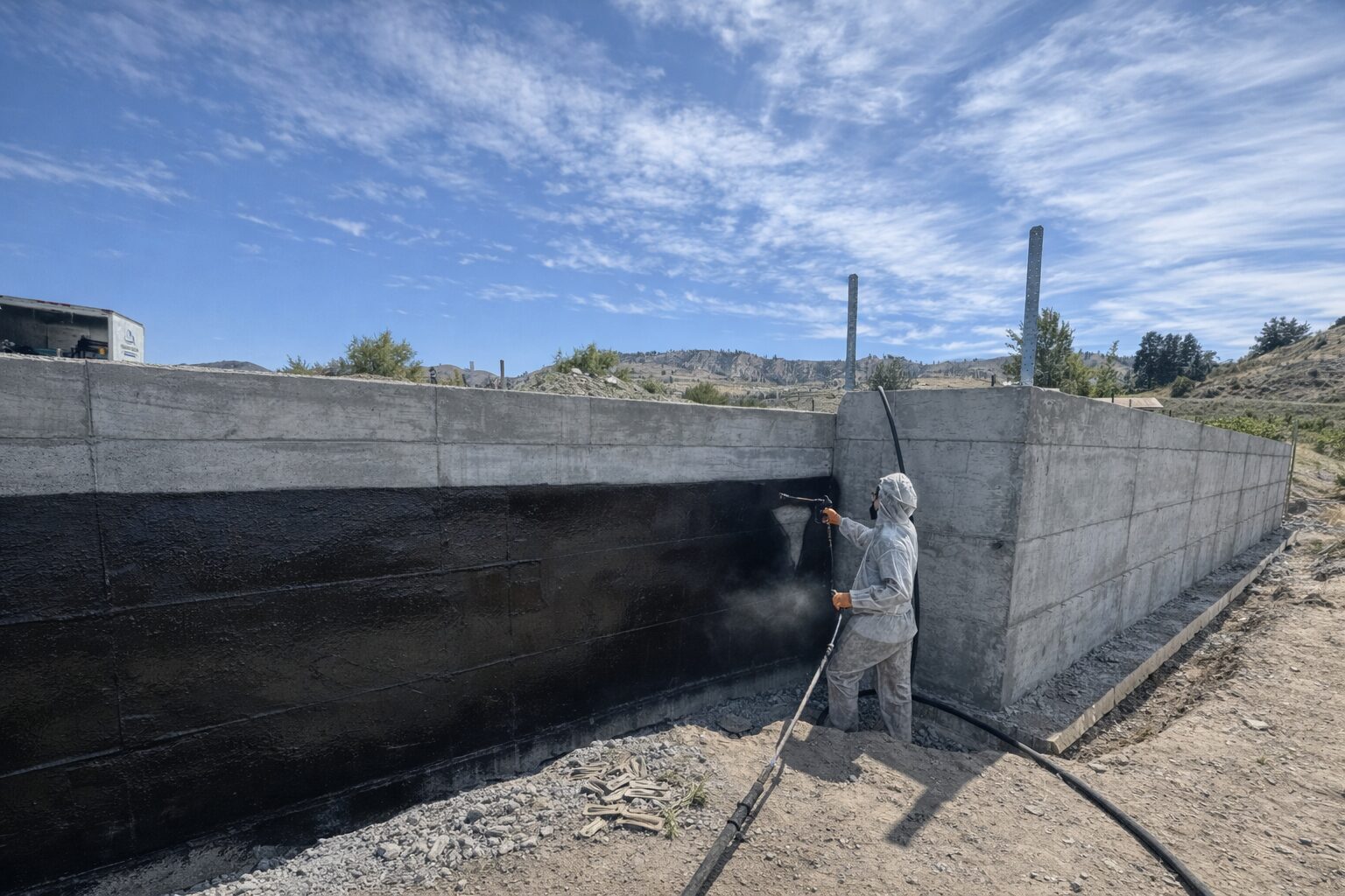 Applying foundation waterproofing coating to new construction foundation wall before backfill